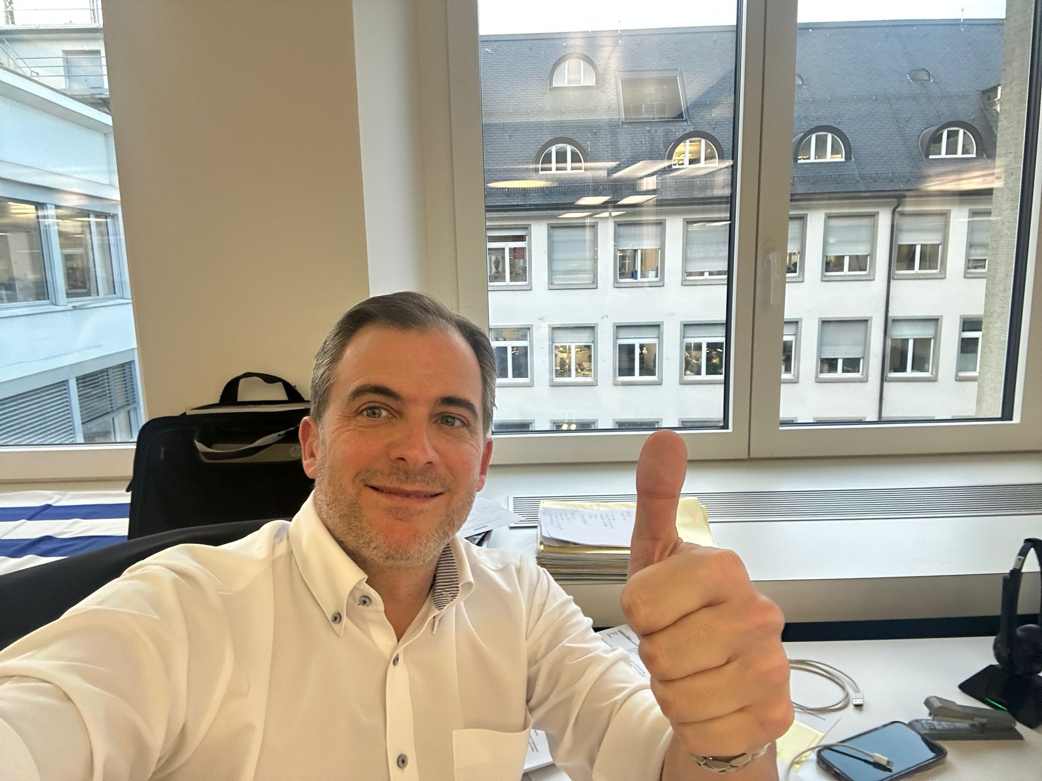 Diego in Zurich office with thumbs up