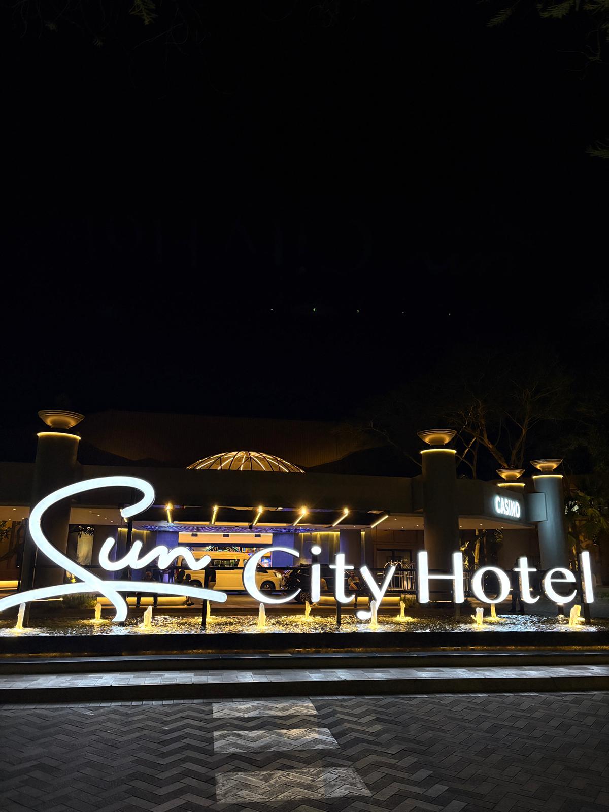 Sun City Hotel by night — casino lights calling